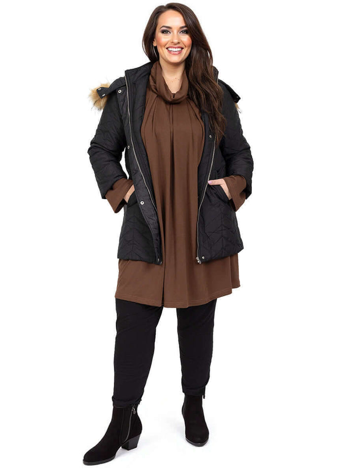 Plus size woman in Estelle Jacket - Black over a brown dress, showcasing winter fashion and warmth.