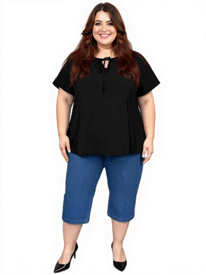 Women’s Plus Size Yasmin Top in black with keyhole tie and flutter sleeves, styled with denim capris.