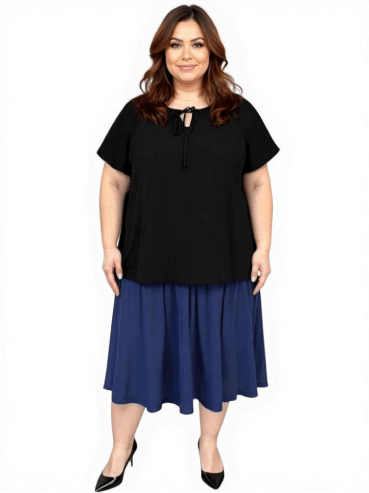 Women’s Plus Size Yasmin Top in black with flutter sleeves, styled with a flowy skirt, by Dale and Waters.