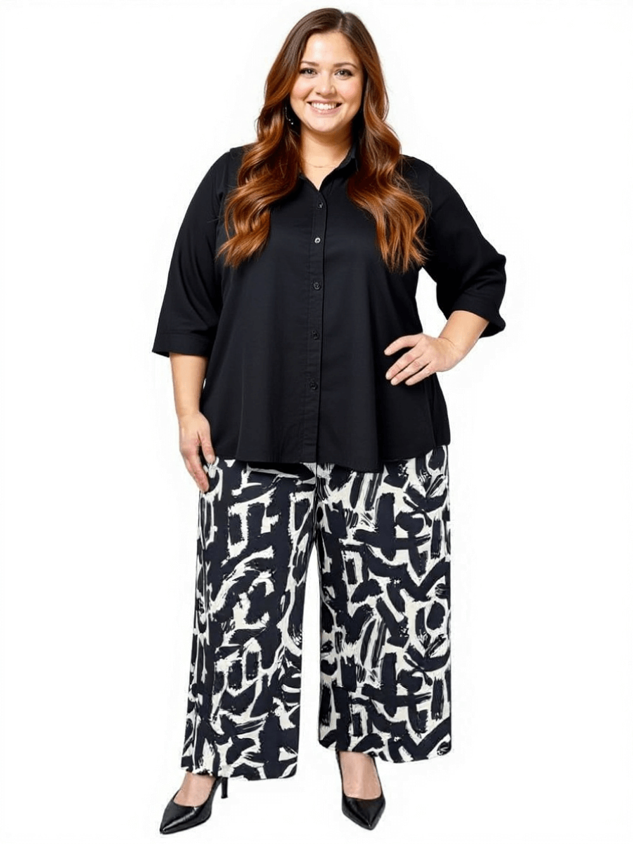 Plus size woman in black shirt and black & cream print wide-leg Johanna Pants by Dale and Waters, showcasing effortless style.