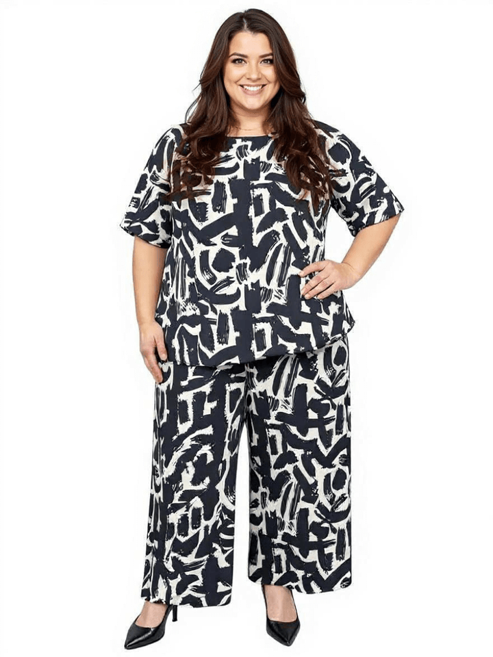 Women’s Plus Size Johanna Top by Dale and Waters in black and cream print, styled with wide-leg pants.
