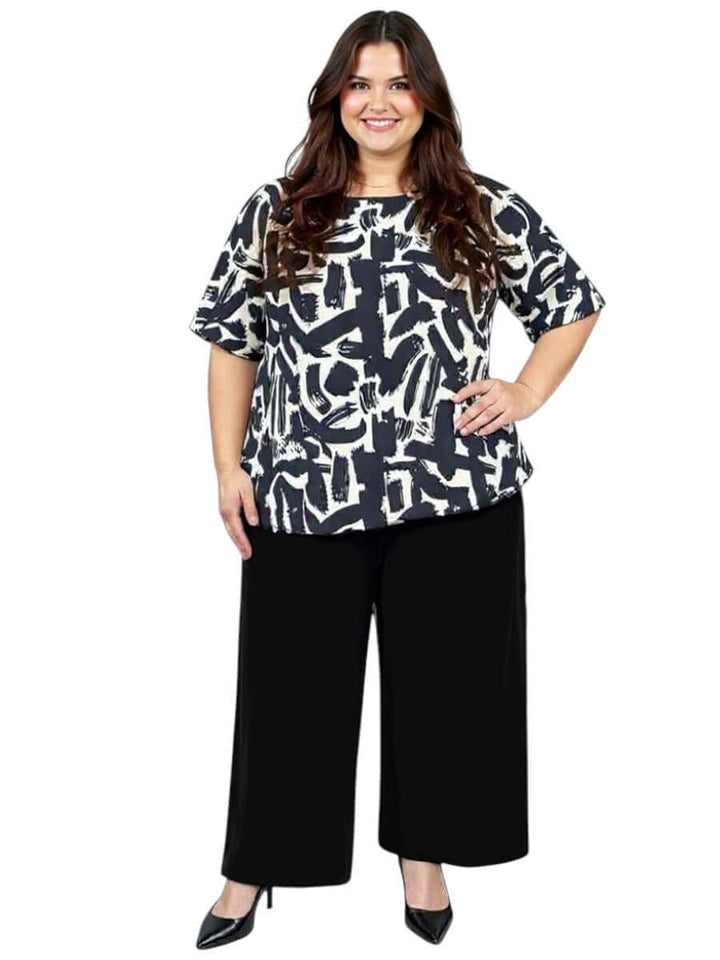 Women’s Plus Size Johanna Top in Black and Cream print by Dale and Waters, styled with black palazzo pants.