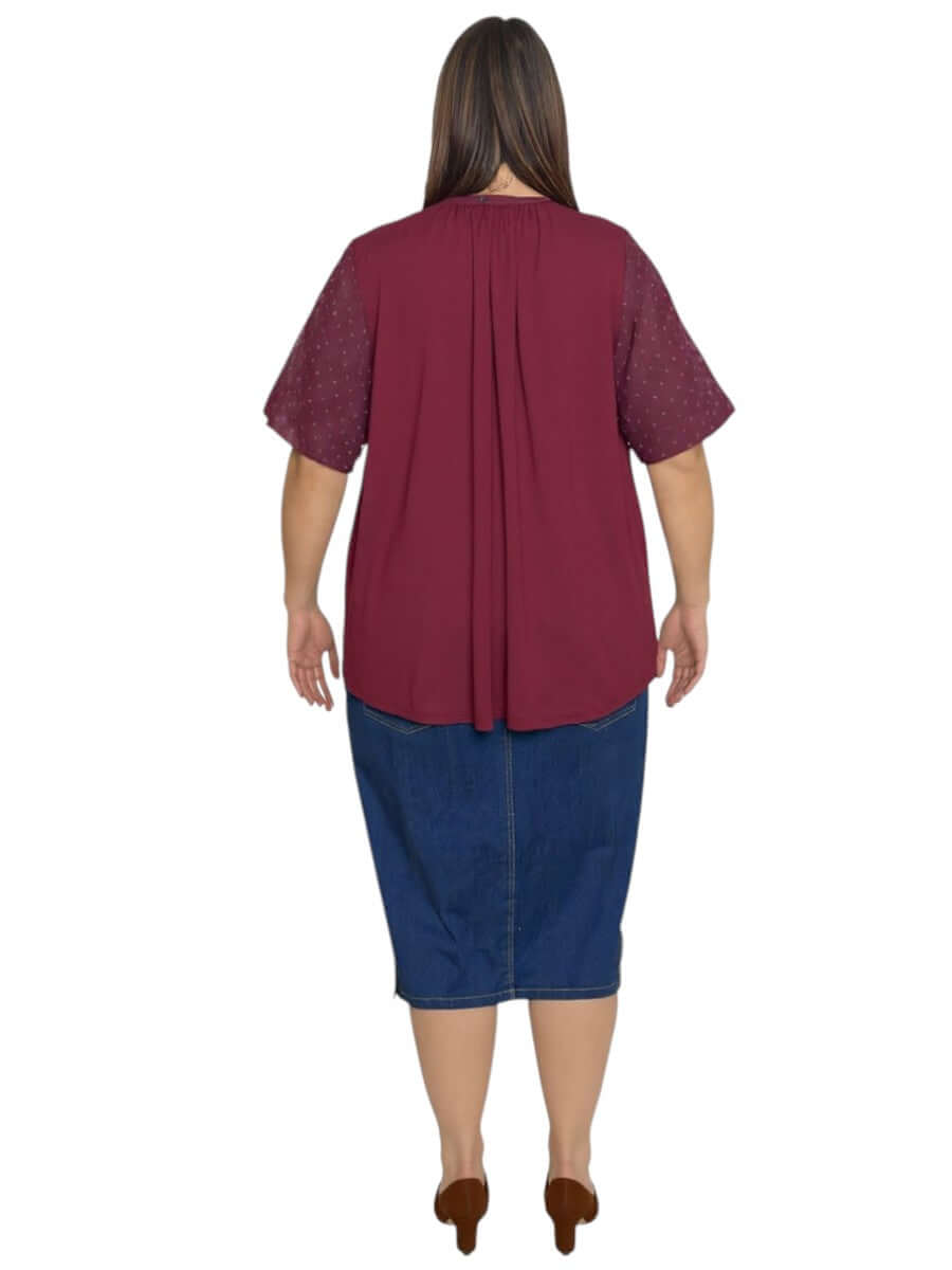 Dale and Waters women's plus size Naya Top in wine featuring textured sleeves and a flowing back, styled with a denim skirt.