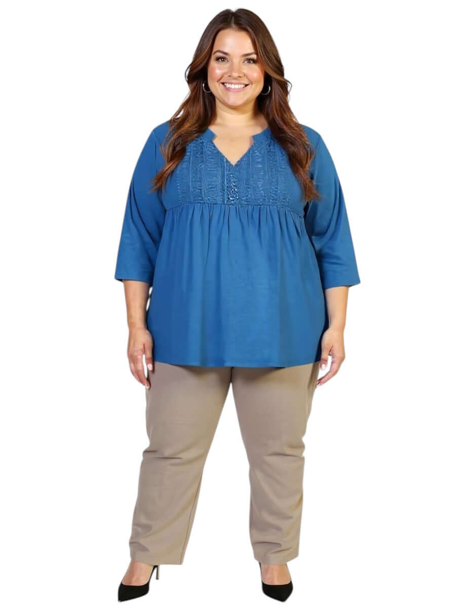 Plus size Bellamy Top in teal from Dale and Waters with lace bib and pleats, paired with beige pants, perfect for casual or elevated styling.
