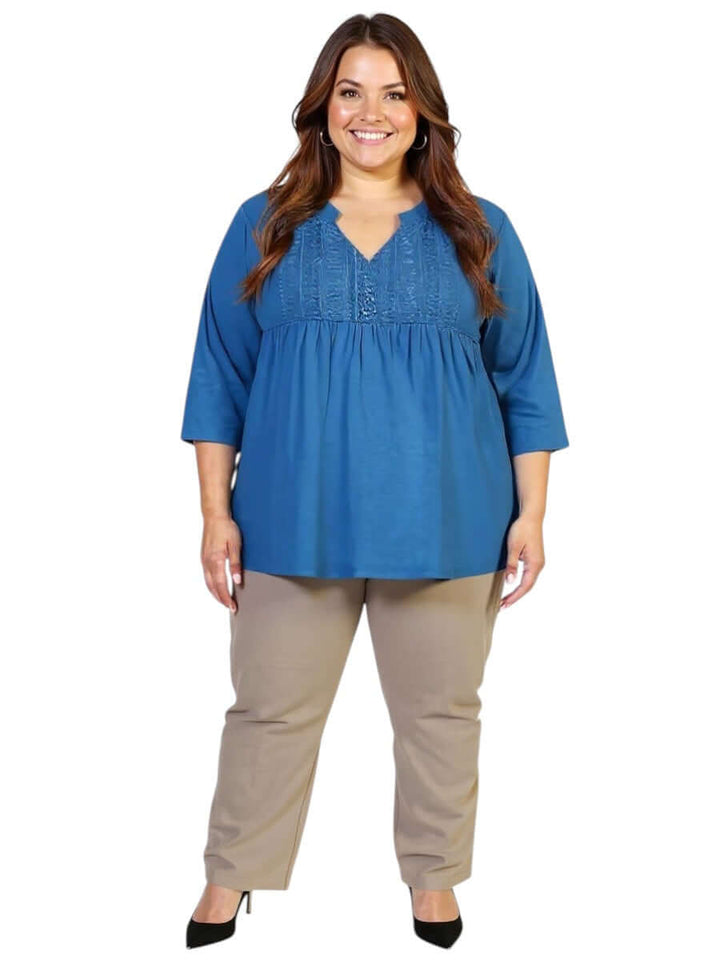 Plus size Bellamy Top in teal from Dale and Waters with lace bib and pleats, paired with beige pants, perfect for casual or elevated styling.