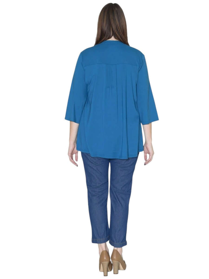 Back view of the Bellamy Top in teal, featuring a pleat design and three-quarter sleeves, paired with casual jeans.