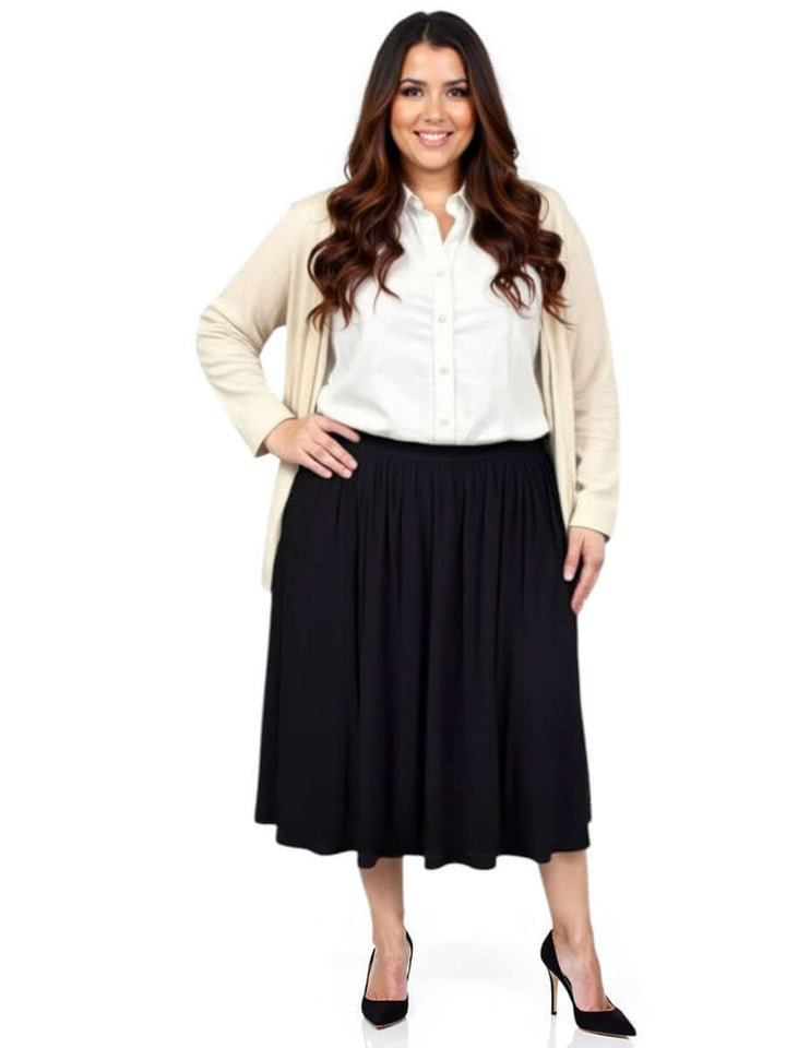 Plus size woman wearing the Mercedes E2E Cardi in stone over a white blouse and black skirt.