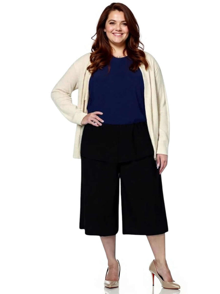 Plus size model wearing Dale and Waters Mercedes E2E Cardi in stone with black culottes.