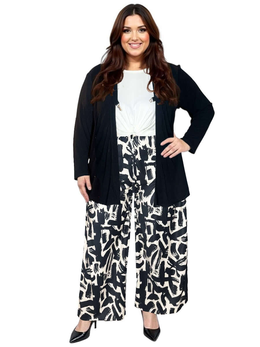 Plus size woman wearing a black Mercedes E2E Cardi, styled with patterned wide-leg pants and a white top.