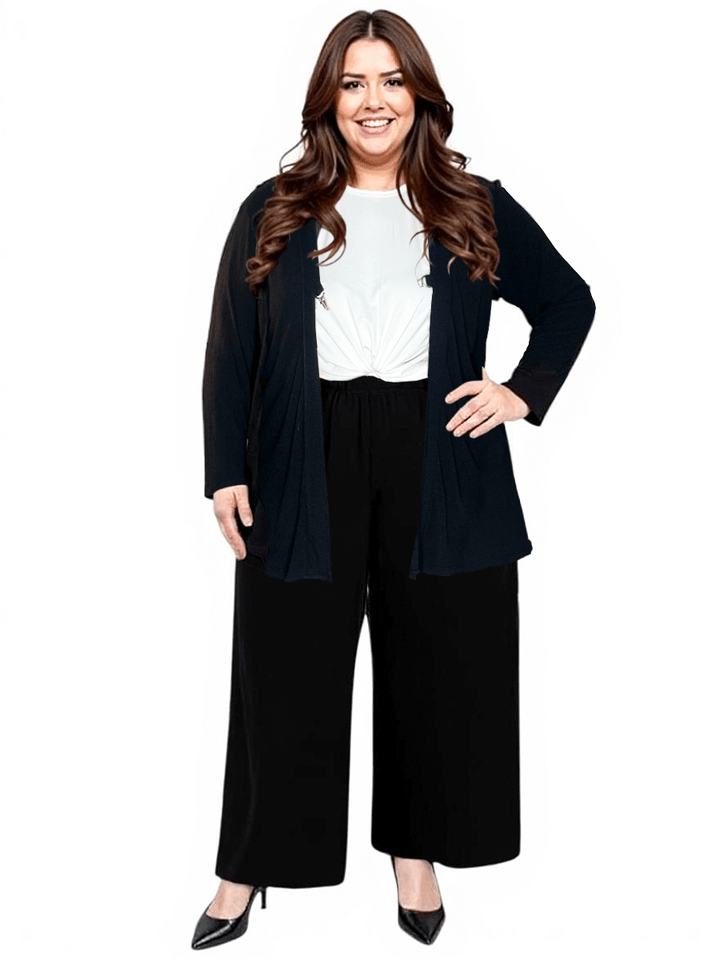 Plus size woman wearing a black Mercedes E2E cardigan over a white top and black pants, looking stylish and confident.