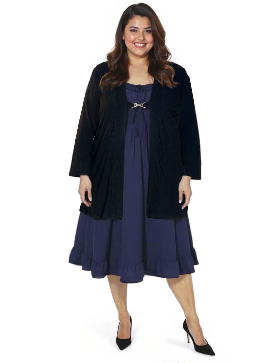Plus size model wearing a black Mercedes E2E cardigan over a stylish blue dress, showcasing a trendy layered look.
