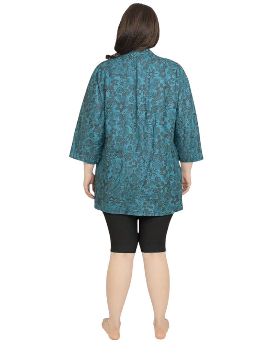 Back view of Women's Plus Size Shadow Tropics Swim Rashi in teal floral print by Dale and Waters, featuring ¾ sleeves.
