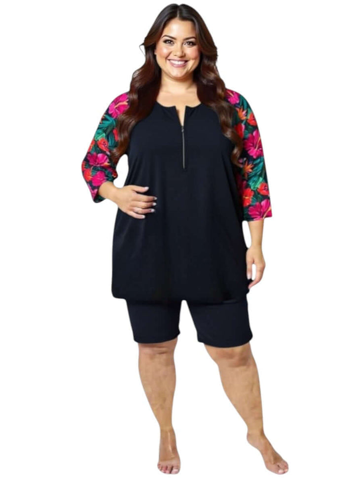 Hibiscus Bloom Tunic Swim Rashi - Black Print for plus size women, featuring vibrant floral sleeves and a stylish zip front.