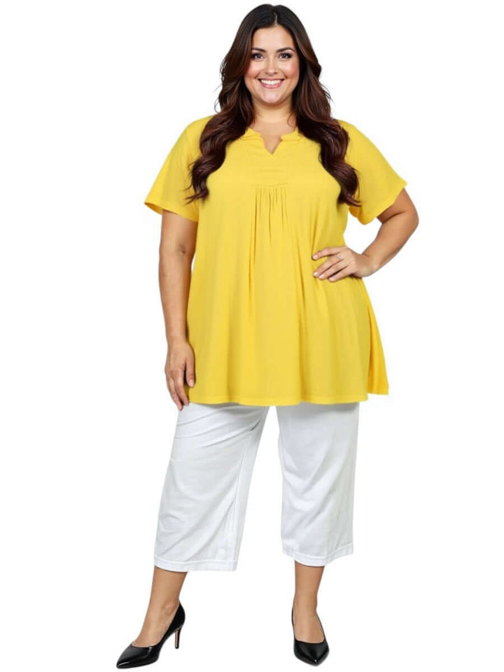 Woman wearing Love Is In The Air Pants - White with a yellow top, showcasing plus size fashion and comfort.