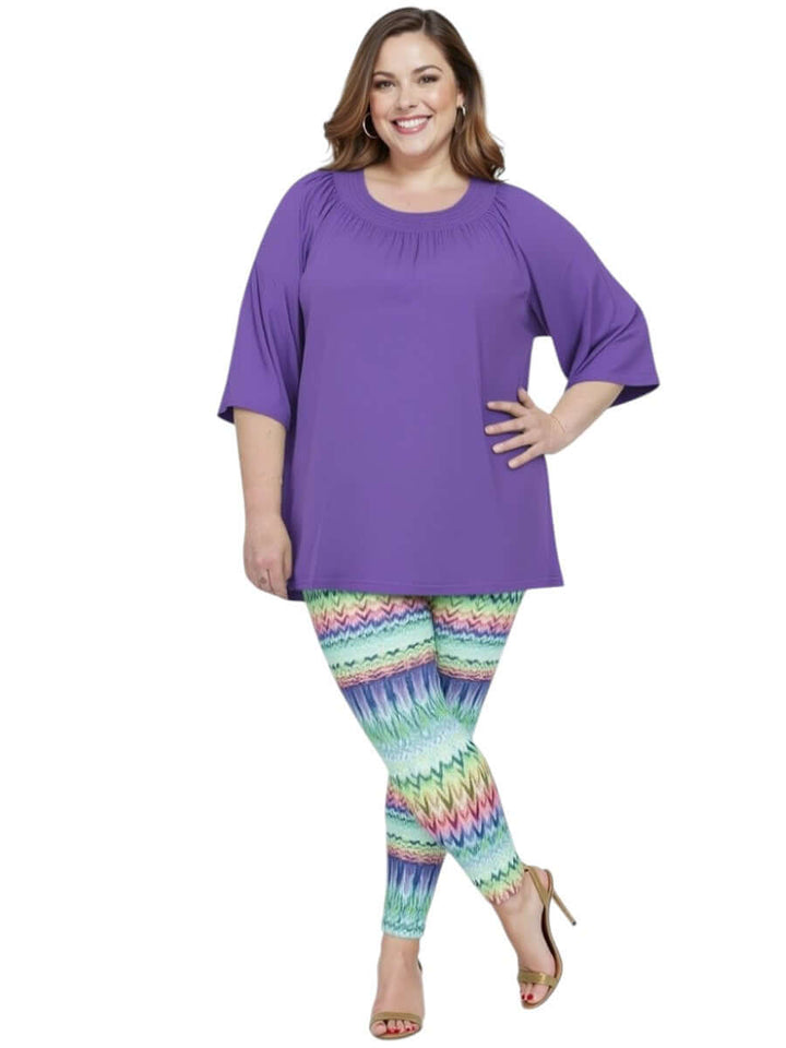 Women’s plus size model in purple top and Atlas Leggings - Multi Print showcasing vibrant patterns.
