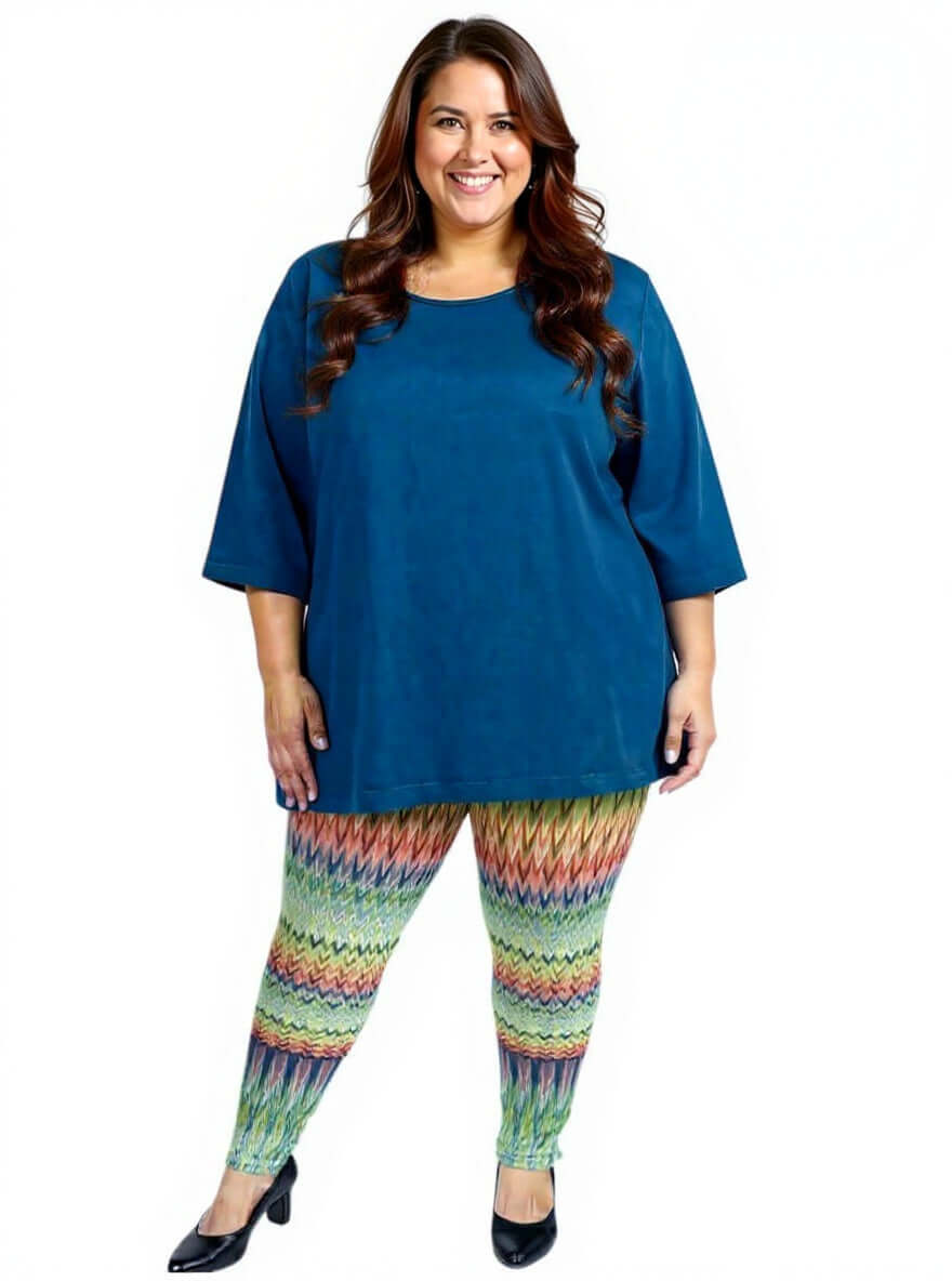 Woman wearing plus size Atlas Leggings - Multi Print and a blue top, showcasing vibrant pattern and comfortable fit.
