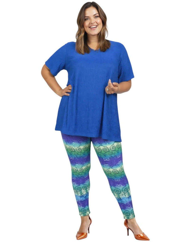 Model wearing Atlas Leggings - Purple Print with a blue top, showcasing plus size women's fashion.