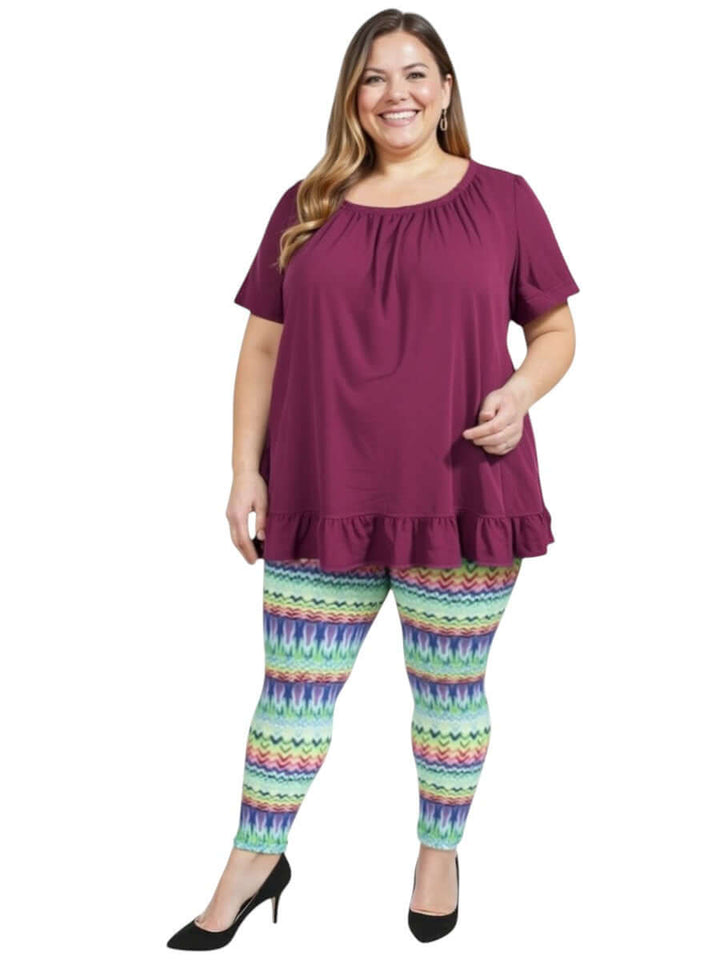 Plus size woman wearing Atlas Leggings - Multi Print with a purple top, showcasing colorful and stylish comfort.