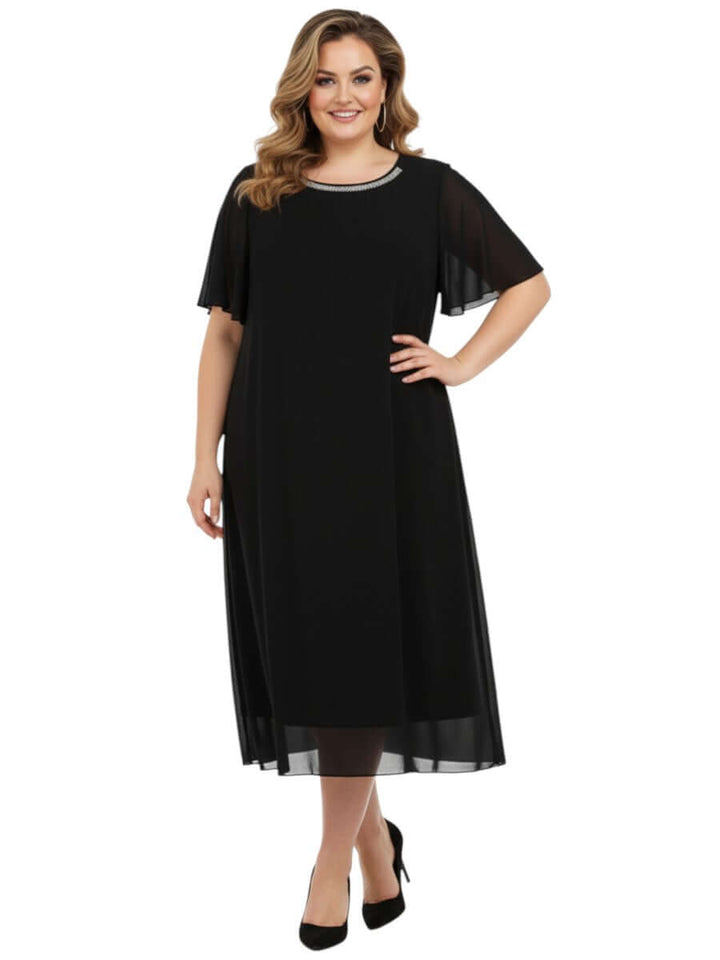 Ariel Diamanté Dress - Black worn by a plus size woman, showcasing its elegant design and sheer mesh overlay.