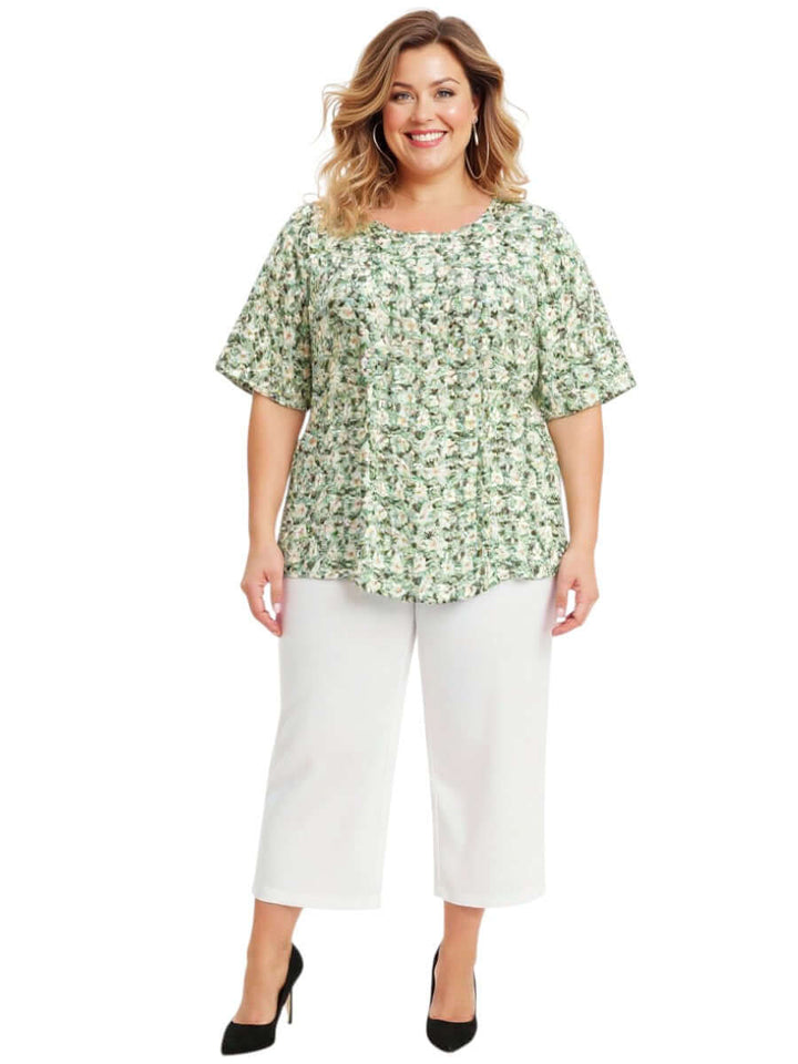 Mogan Bib Top - Green Print worn by plus size woman in soft mint and white floral design with smocked bib neckline.