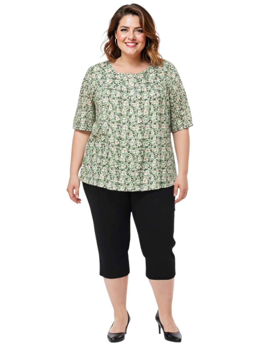 Mogan Bib Top - Green Print on a plus size woman, featuring a floral design with elegant smocked neckline.