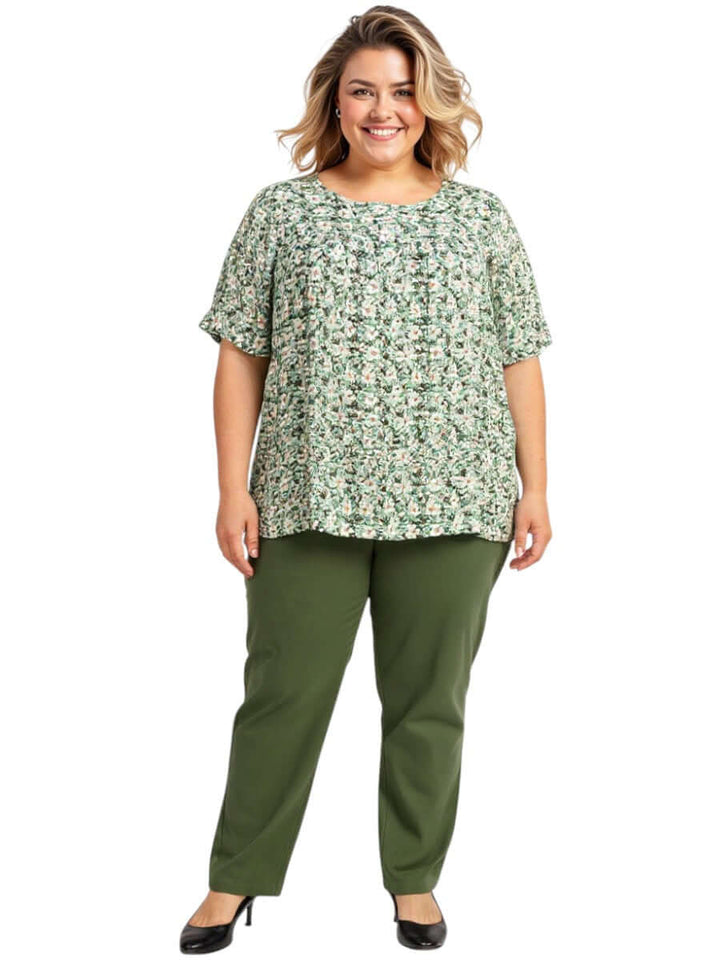 Mogan Bib Top - Green Print worn by a plus size model, featuring a daisy-like print in soft mint and white.