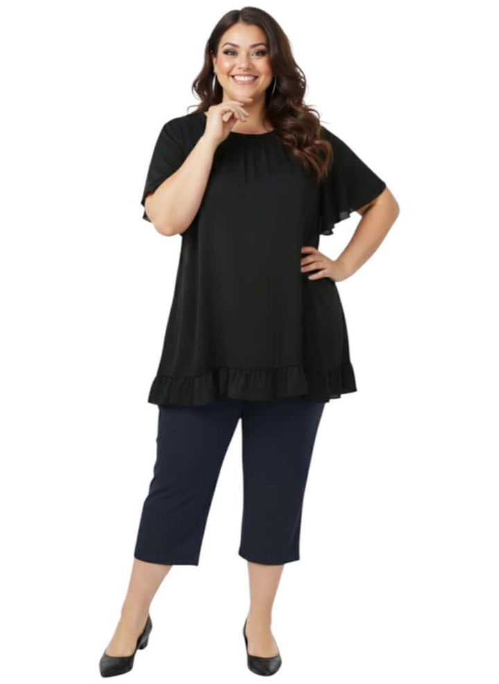Landra Top - Black worn by a plus size woman, showcasing flutter sleeves and ruffle hem in an elegant, comfortable fit.