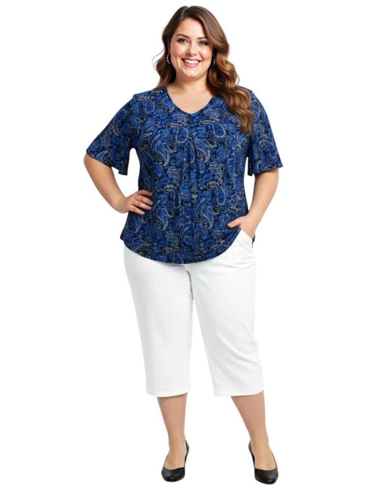 Plus size women's Westin Top - Blue in paisley print, featuring a V-neckline and paired with white pants.