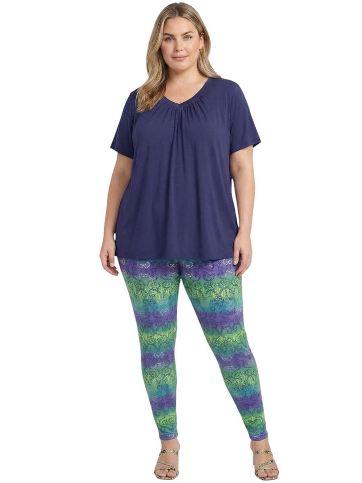 Montez Top - Blue worn by a woman, showcasing a stylish plus size outfit with colorful leggings.