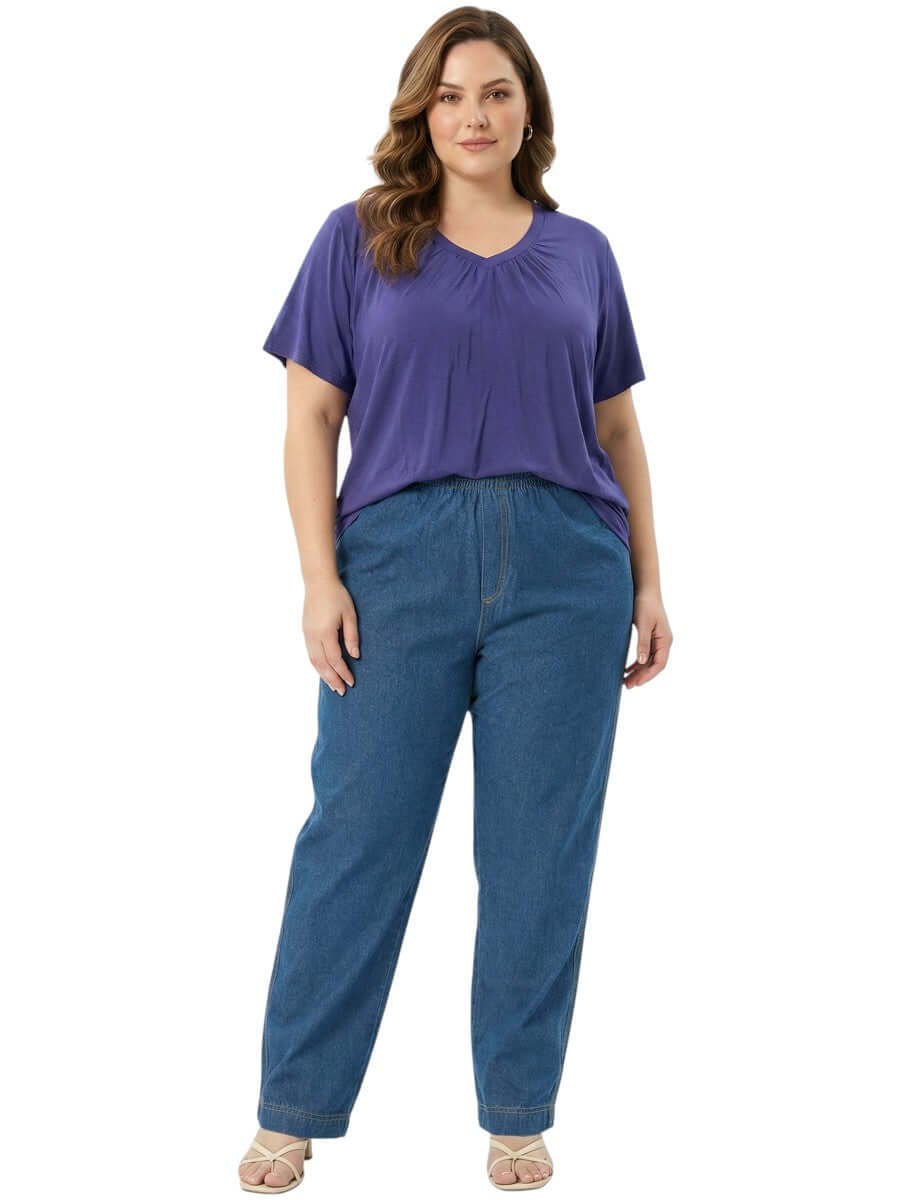Model wearing Montez Top - Blue with relaxed-fit jeans, showcasing a stylish plus size women's fashion outfit.