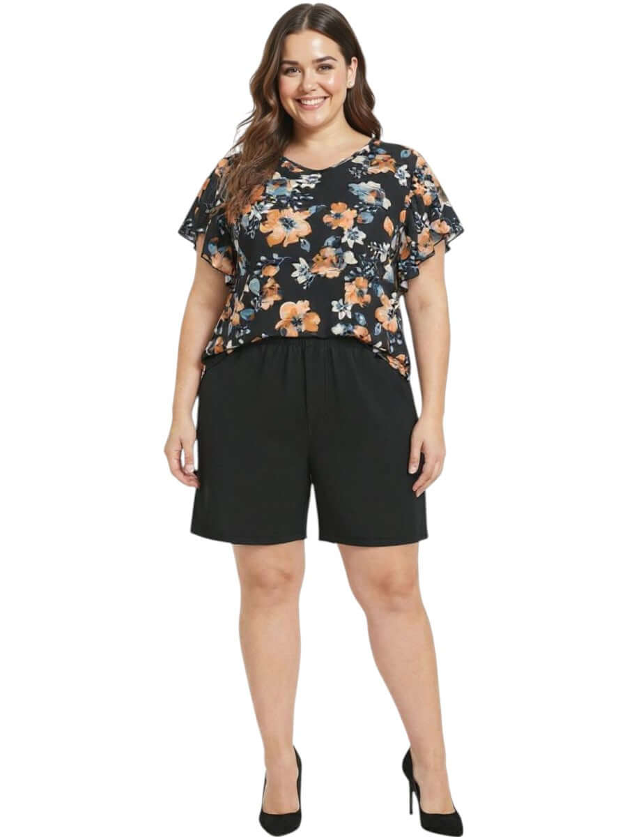 Kerissa Top - Black Print worn by a plus-size woman, featuring floral design and black shorts, stylish women's fashion.