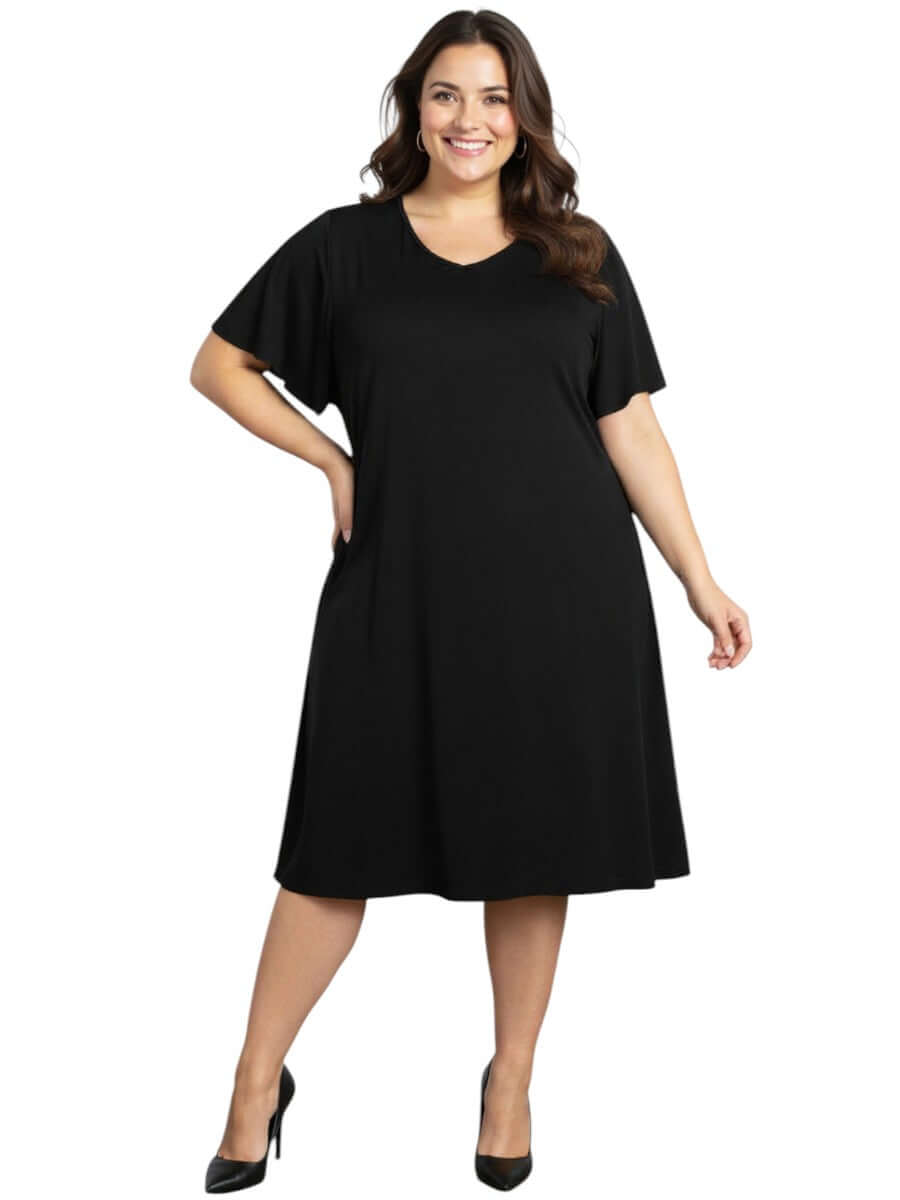 Plus size woman wearing the Westley Dress - Black with flutter sleeves and a relaxed A-line fit.