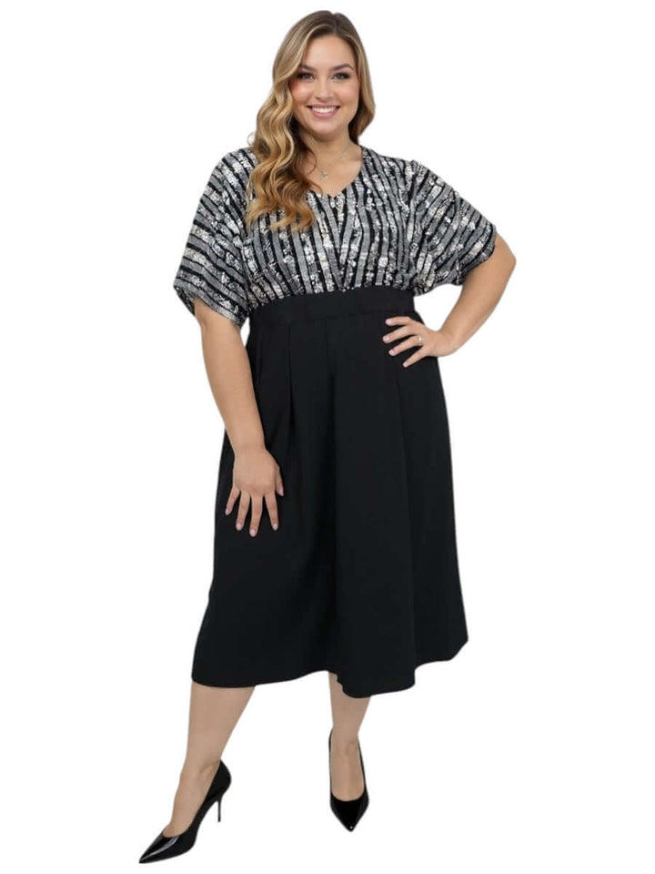 Plus Size Midnight Sonata Dress in Black by Dale and Waters, featuring a sequin bodice and soft dolman sleeves.