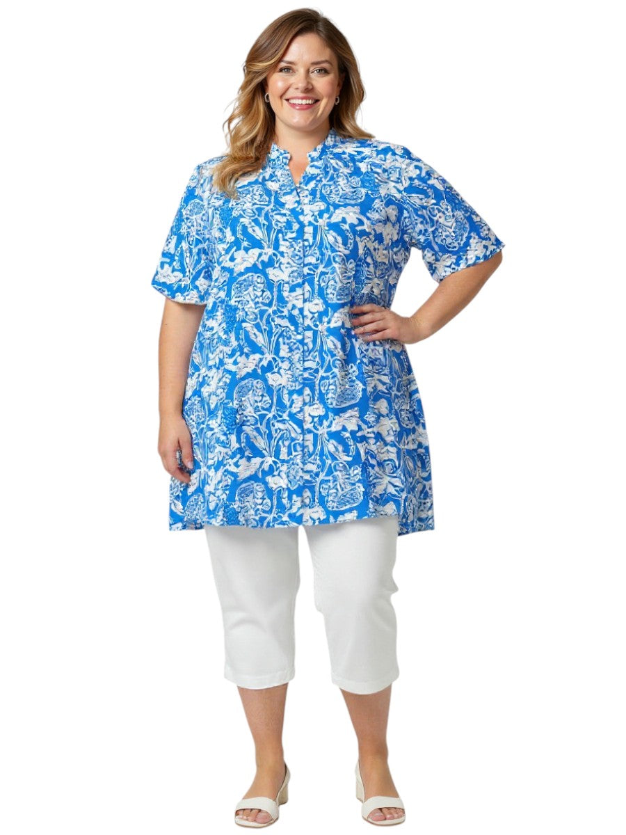Women’s plus size model wearing the Austen Tunic - Blue Print with a mandarine collar and flowy fabric.