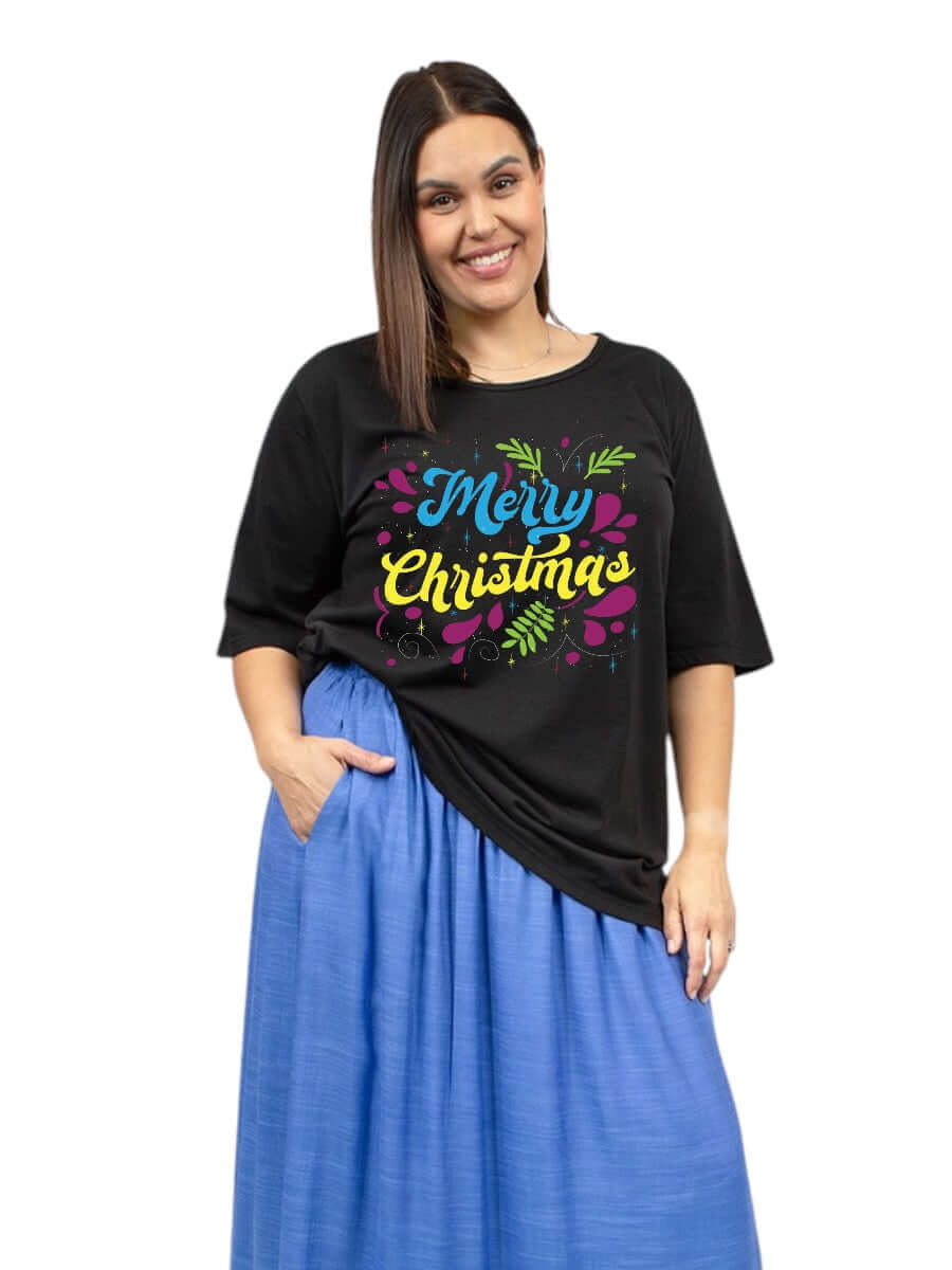 CHRISTMAS Round Neck Tees - Cotton Spandex featuring colorful 'Merry Christmas' design on black tee, model wearing blue skirt.