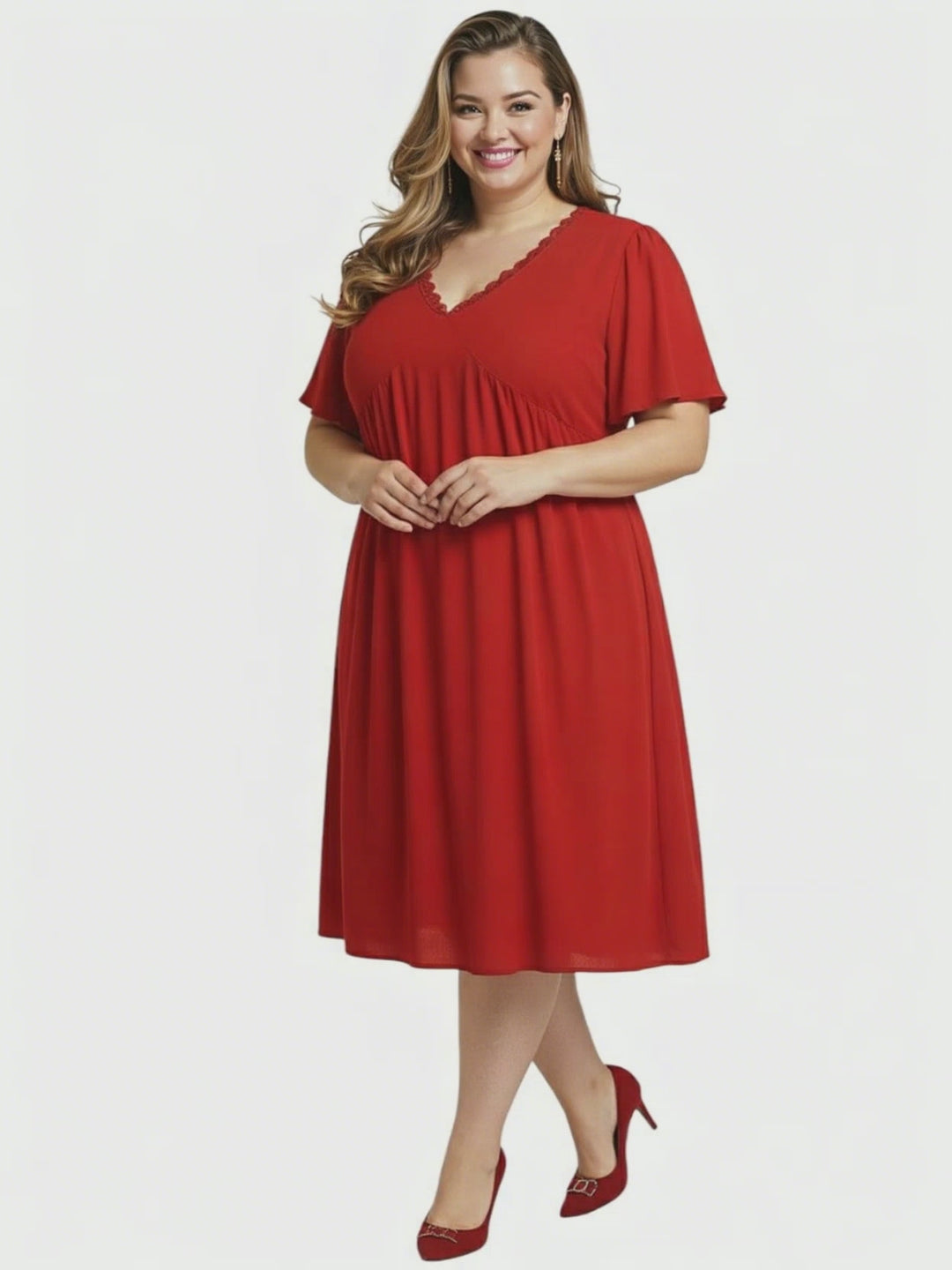 Angelica Dress - Red worn by a plus size woman, featuring flattering V-neckline and flowing polyester fabric.