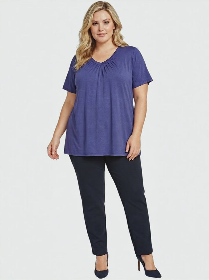 Women in a plus size Montez Top - Blue, featuring a rich violet-blue hue, styled with black pants for a chic look.