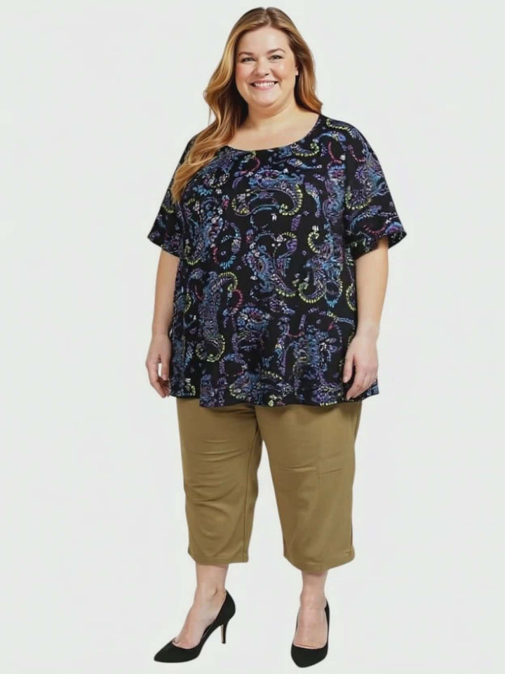 Estela Top - Black Print worn by a plus-size woman, featuring a flowy design and short sleeves for comfortable everyday wear.