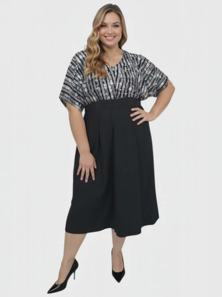Plus Size Midnight Sonata Dress – Black by Dale and Waters, featuring a sequin bodice and soft dolman sleeves.